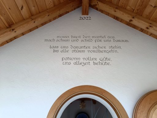 Wandinschrift in einem Holzbodenhaus mit dem Jahr 2002 und poetischem Text.