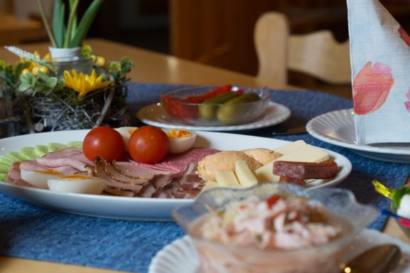 Ein reichhaltiges Frühstücksbuffet mit Aufschnitt, Käse, Tomaten und Salat.