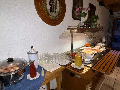 Buffet mit Getränken, Snacks und frischen Früchten auf einem Tisch in einem gemütlichen Raum.