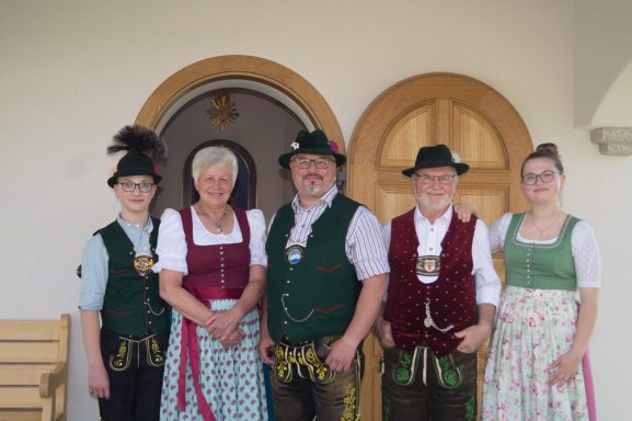 Rupert Vodermaier und Familie in traditioneller Tracht stehen vor einer Tür.