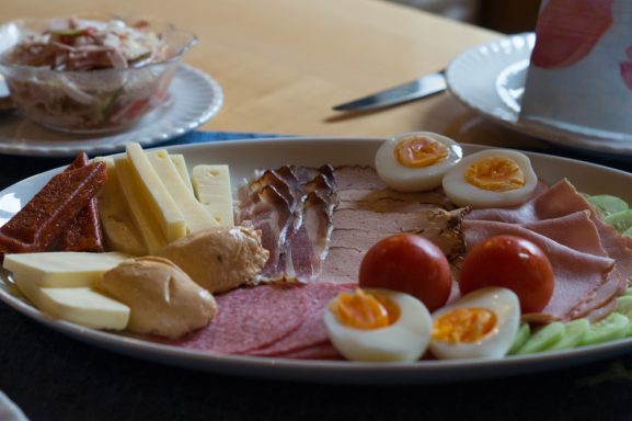 Ein Teller mit Käse, Wurst, Eiern, Tomaten und Salat.