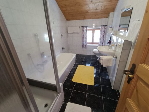 Modernes Badezimmer mit Dusche, Badewanne, Waschbecken und Fenster.