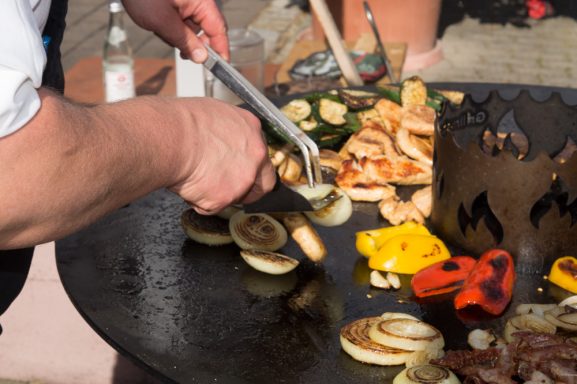 Rupert Vodermaier grillt verschiedene Gemüsesorten auf einer großen Grillplatte.