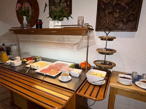 Ein Frühstücksbuffet mit Aufschnitt, Käse, Obst und Brötchen auf einem Holztablett im Gartlacher Hof.